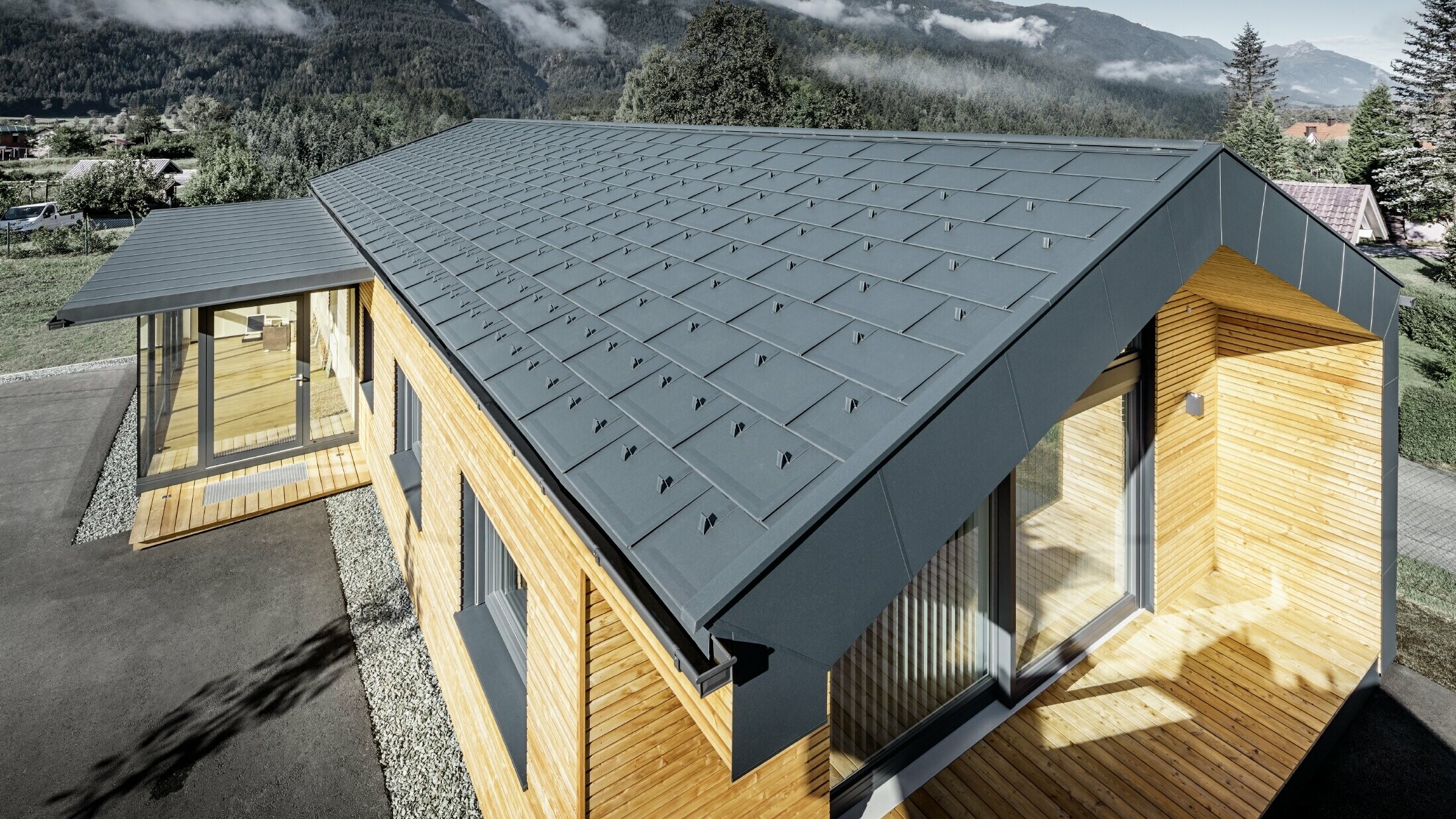 Nouvel immeuble de bureaux de Holzbau Faltheiner avec une façade en bois de mélèze, des fenêtres généreuses et une toiture PREFA en anthracite.