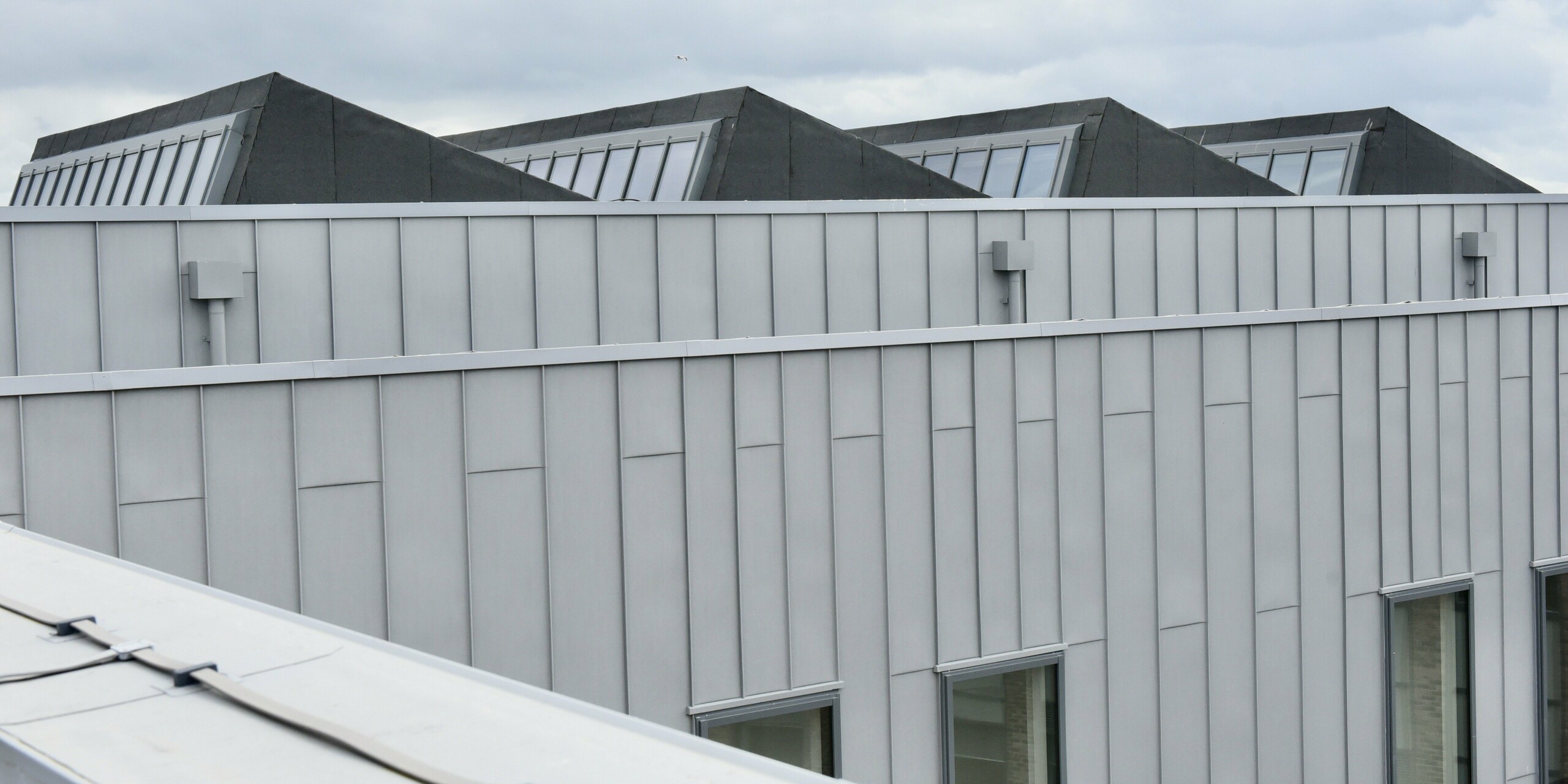 Gros plan du grenier du North Regional College. La façade PREFALZ gris quartz met en valeur la qualité du revêtement en aluminium et souligne la conception bien pensée du bâtiment.