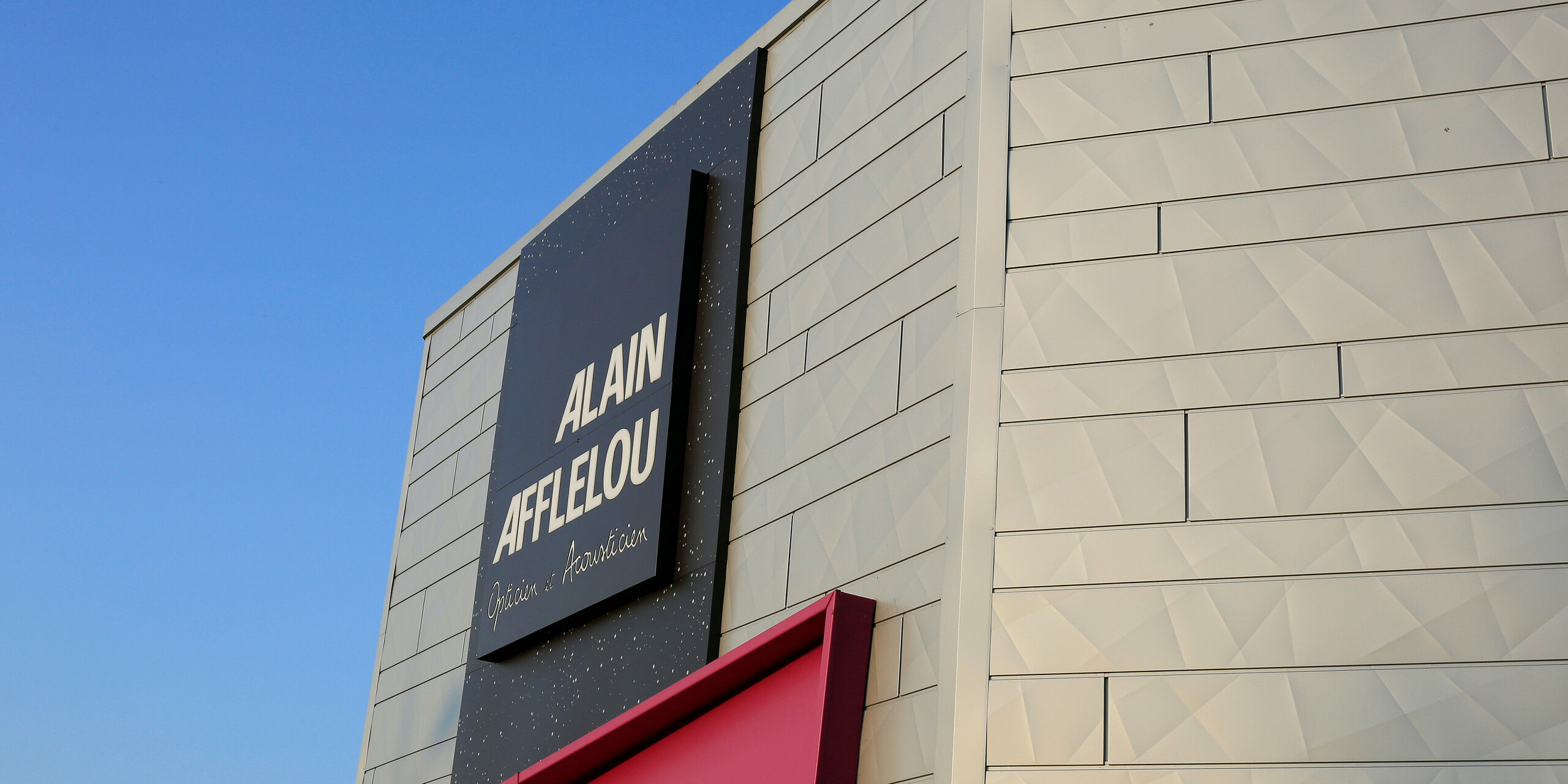 Seitliche Nahaufnahme auf das Firmenschild AFFLELOU am Shop in Auray mit einer silbernen Gebäudehülle aus Aluminium