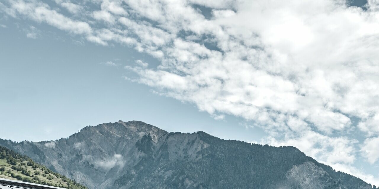 Tetto di un rifugio rustico in Svizzera con facciata in legno e tetto in alluminio di PREFA. La tegola R.16 è stata posata in grigio pietra. Si distinguono il tetto inclinato e la scanalatura.