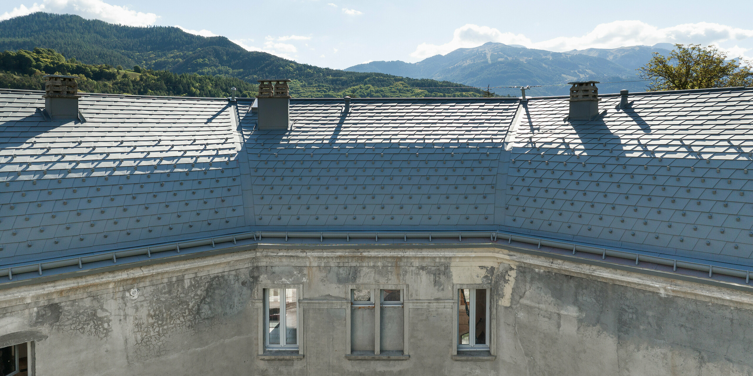 La vaste toiture d'une propriété à Barcelonnette, en France, a été rénovée avec le bardeau de toiture PREFA en P.10 gris souris.