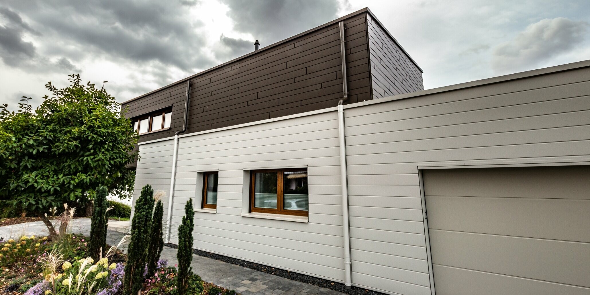 Fassadenverkleidung einer Garage mit den PREFA Sidings horizonal in Weiß, mit Speiereinmündung.