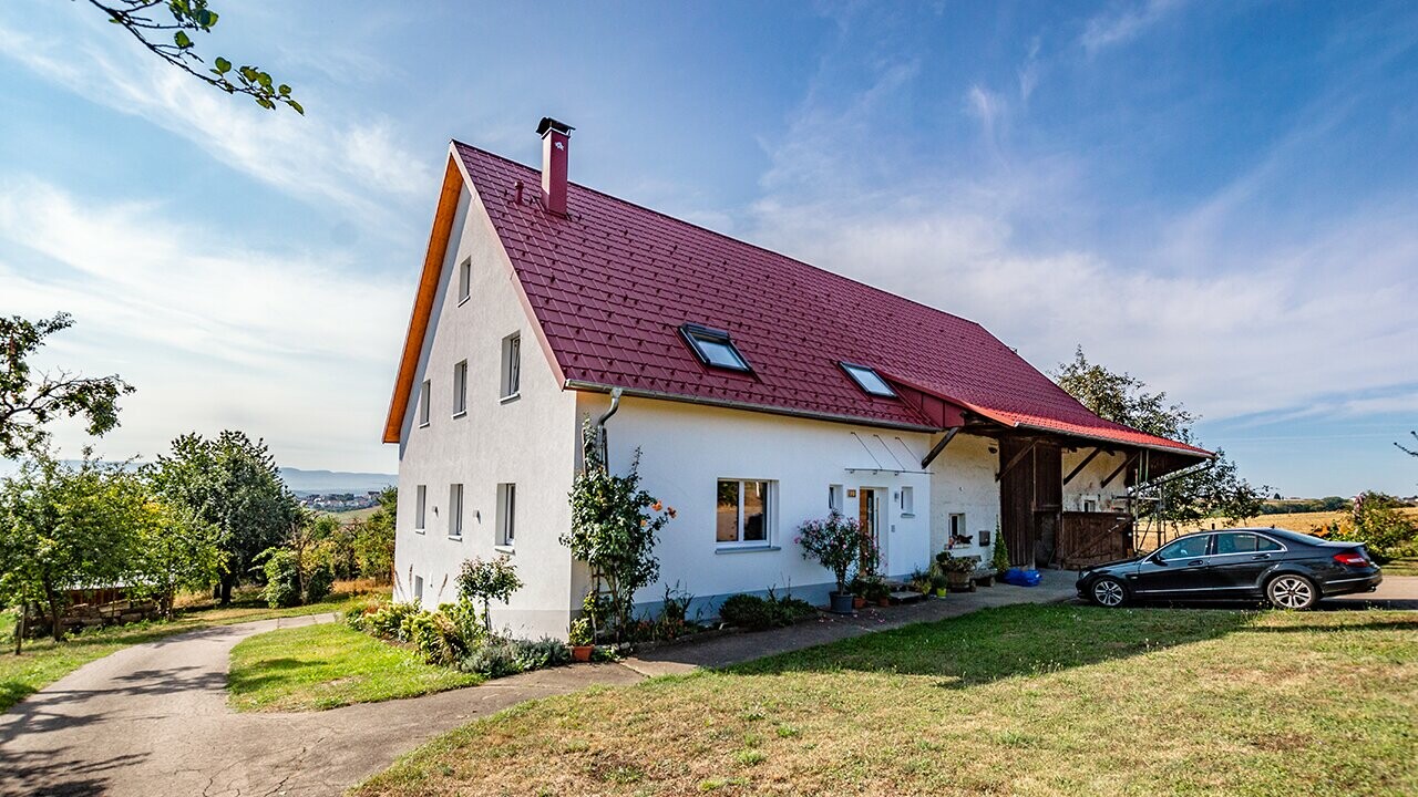 Ancienne fermette à la campagne joliment rénovée avec la tuile PREFA couleur rouge oxyde.