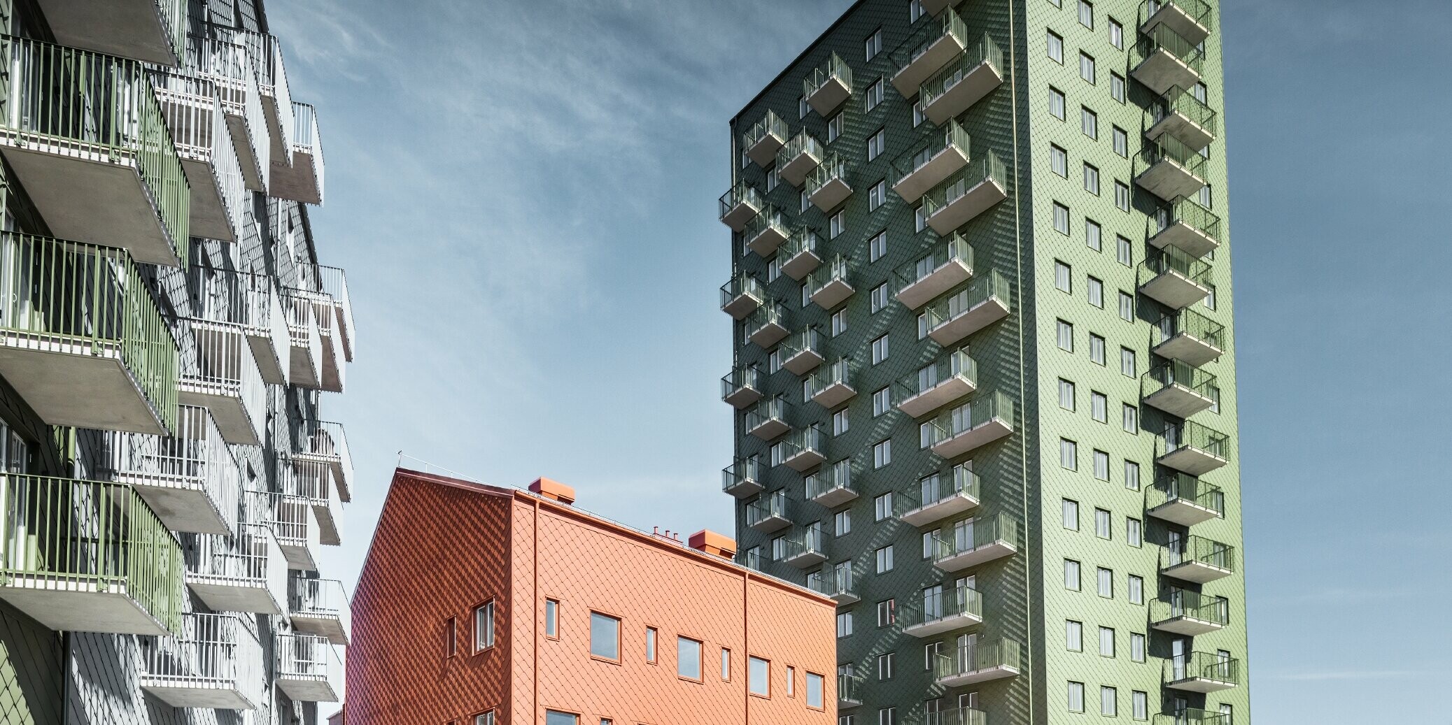 Mehrere Wohnbauten verkleidet mit der PREFA Wandraute 29 × 29 in den Farben Olivgrün, Ziegelrot und Hellgrau in Göteborg, Schweden.