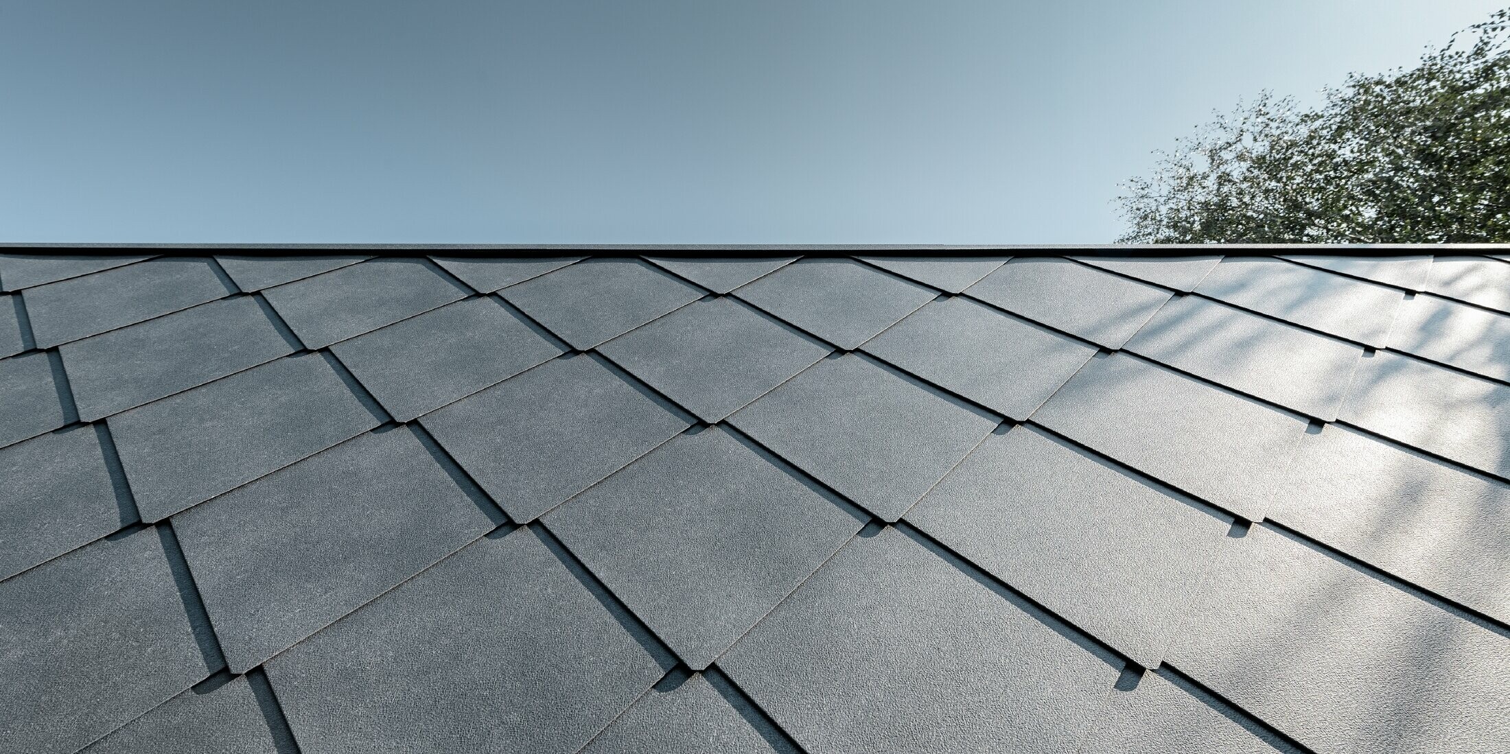 Zubau einer Volksschule eingedeckt mit der Dach- und Wandraute aus Aluminium von PREFA in steingrau