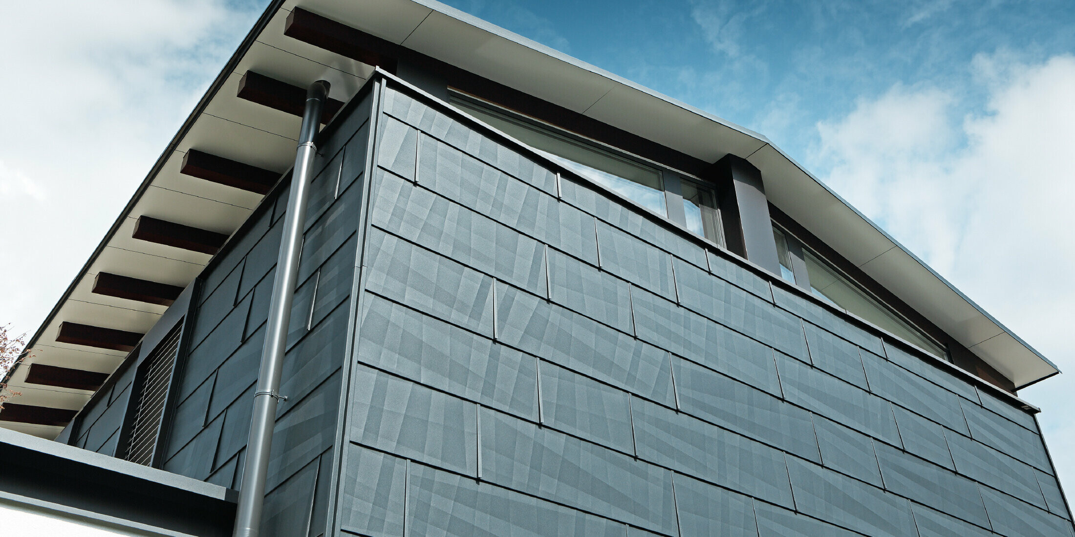 Aufnahme der Dachuntersicht, verkleidet mit der Aluminium Verbundplatte in Weiß, die Fassade wurde mit dem Fassadenpaneel FX.12 in Anthrazit bekleidet