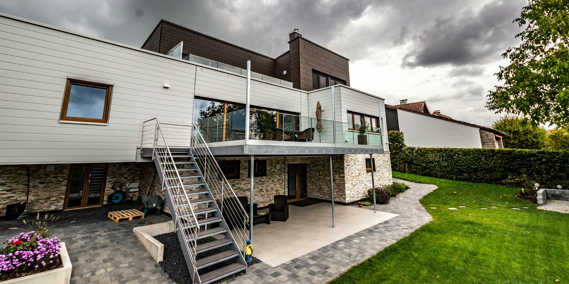 Wohnhaus mit Flachdach und weißer und brauner Fassade mit PREFA Sidings horizontal verlegt.