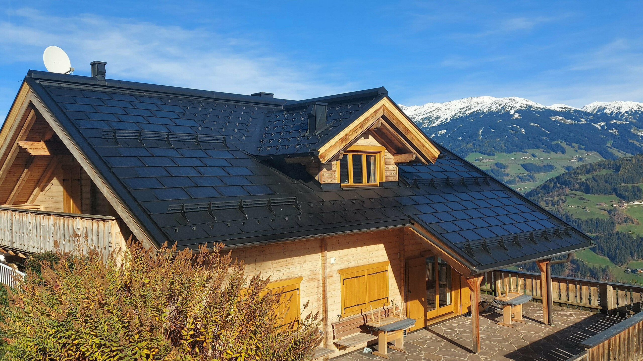 Sanierung eines Einfamilienhauses in Hippach (Tirol) mit der PREFA Solardachplatte klein in P.10 Schwarz, kombiniert mit der PREFA Dachplatte R.16