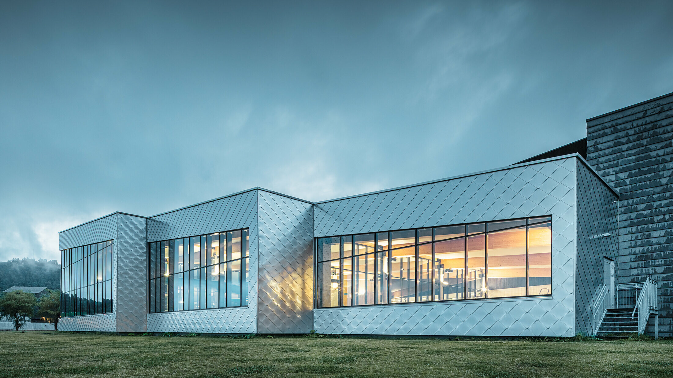 Silber glänzende PREFA Rauten schmücken die Fassade der atemberaubendeden Schwimmhalle "Hardangerbadet" in Norwegen.