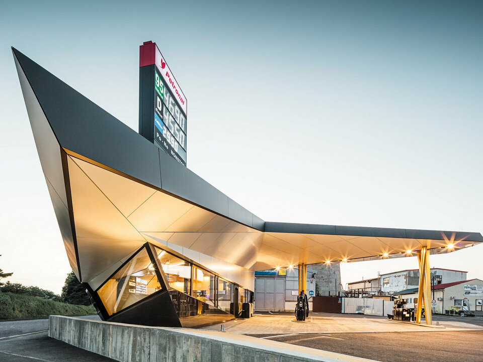 Seitlicher Blick auf die dynamische, mit Aluminium bekleidete Tankstelle von Architekt Daniel Zerzán: Etliche Dreiecke und Trapeze strukturieren die Fassade.