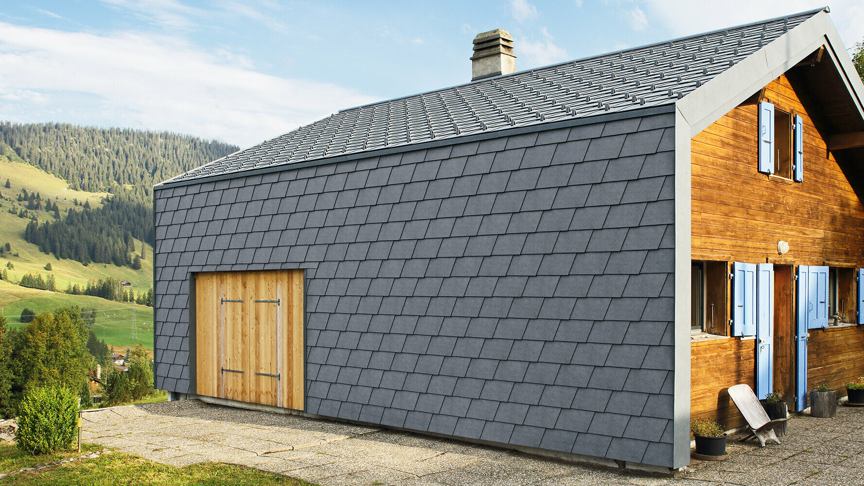 Modernes Einfamilienhaus verkleidet mit PREFA Wandschindeln in der Farbe P.10 Steingrau und Holzelementen.