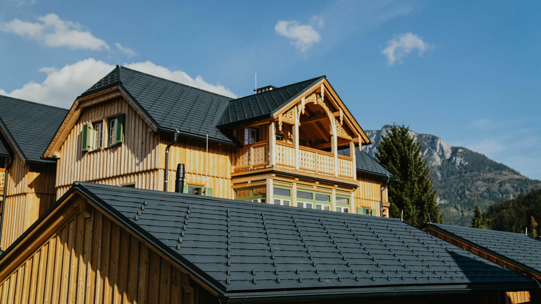 Carport mit PREFA Dachschindeln, im Hintergrund ist das Haus Hackerfeld zu sehen