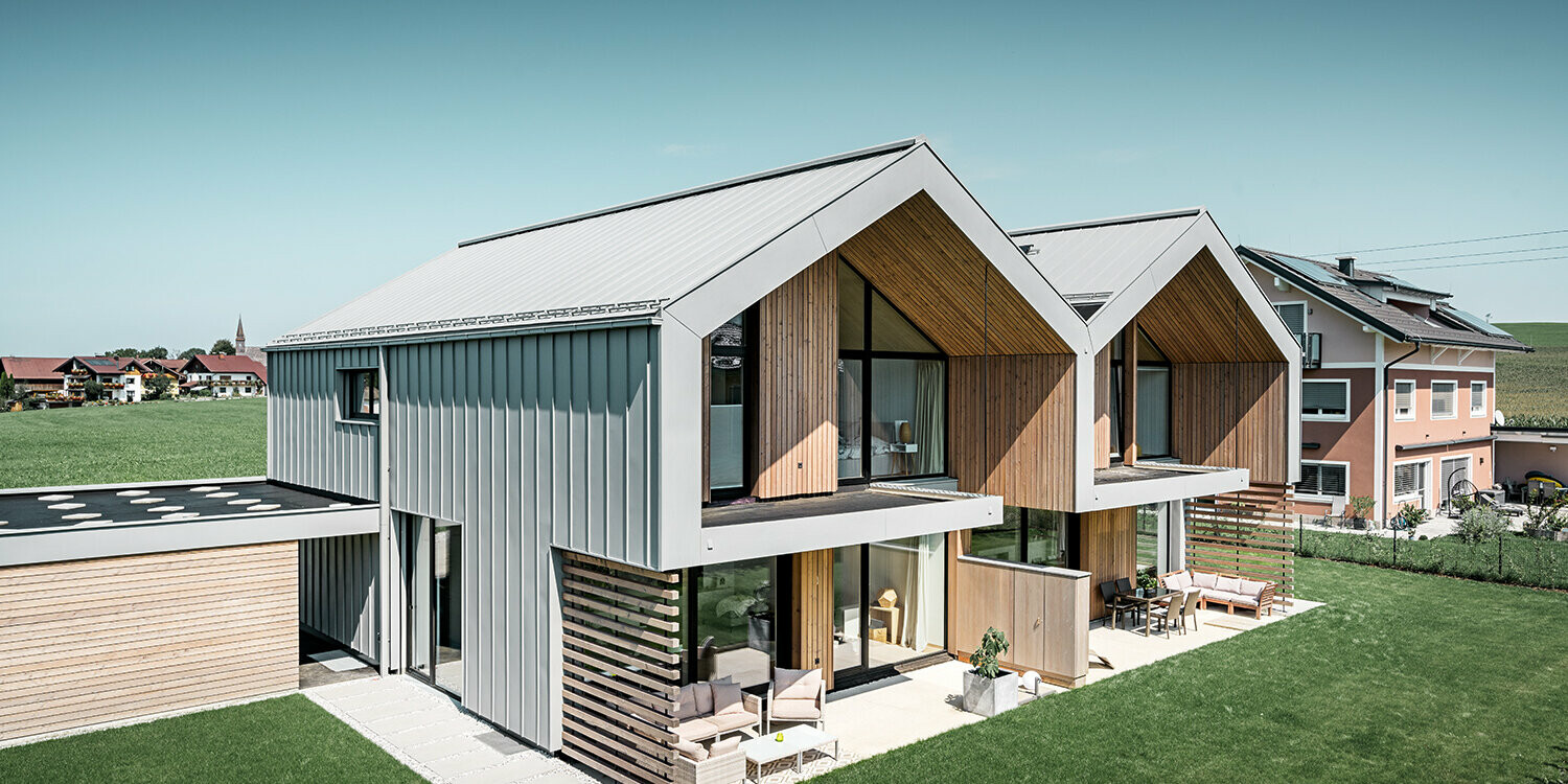 Maisons jumelées modernes avec enveloppe de bâtiment PREFALZ, le toit et la façade sont habillés de PREFALZ couleur gris quartz, tuyau de descente carré compris