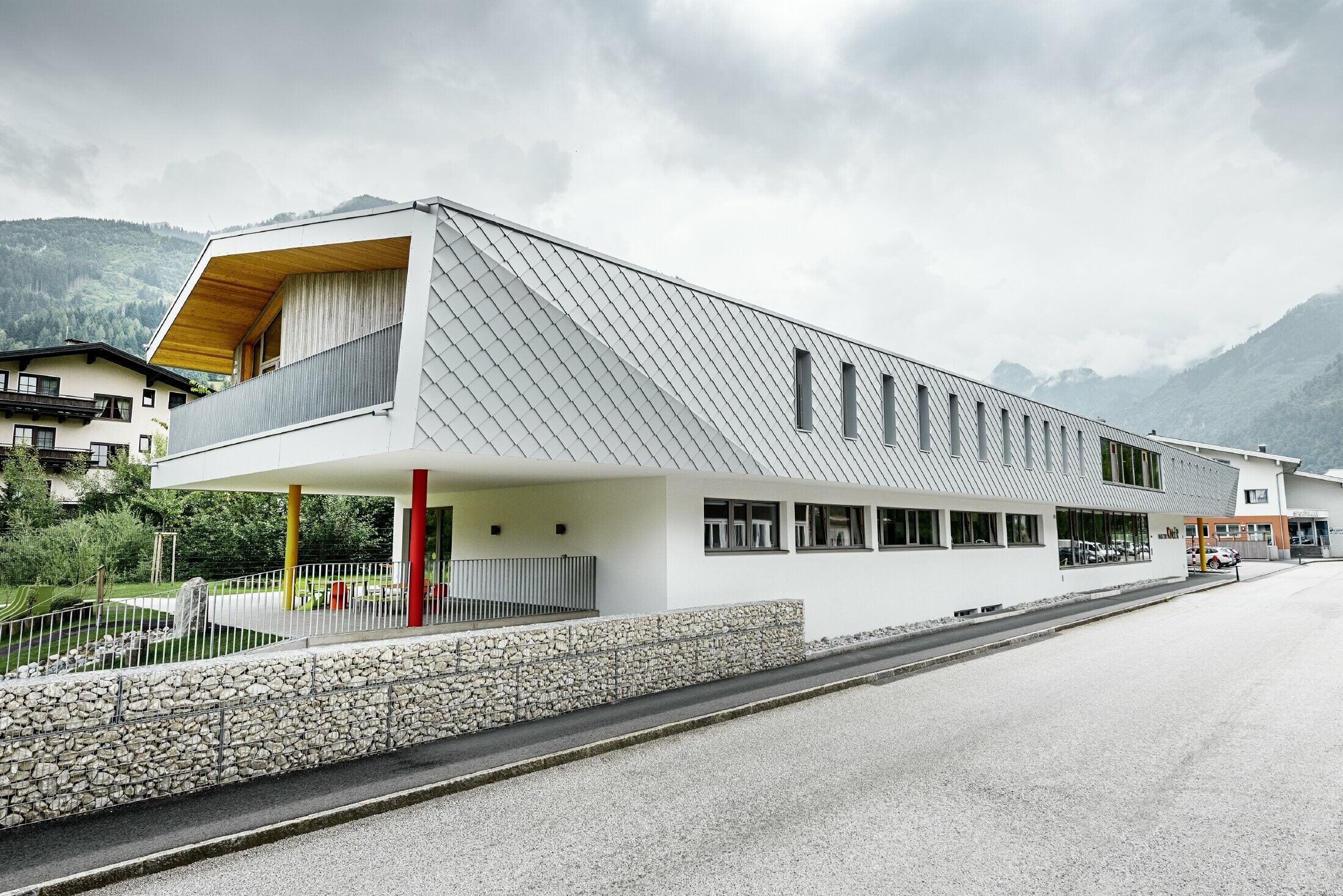 Nuova costruzione della scuola d'infanzia a Kaprun con una facciata moderna con la scaglia PREFA in bianco prefa