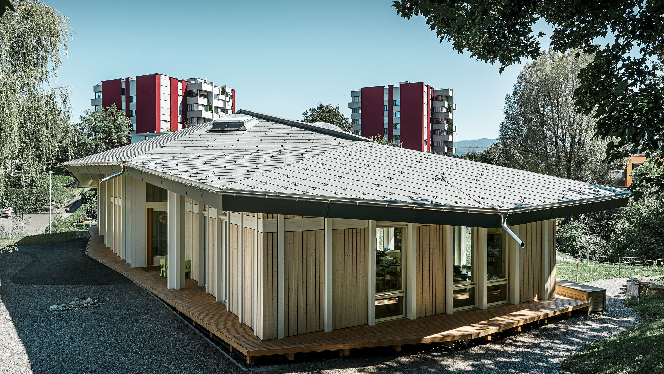 Jardin d’enfants de plain-pied avec panneaux de façade verticaux et toiture en aluminium de PREFA (losange de toiture) couleur gris souris