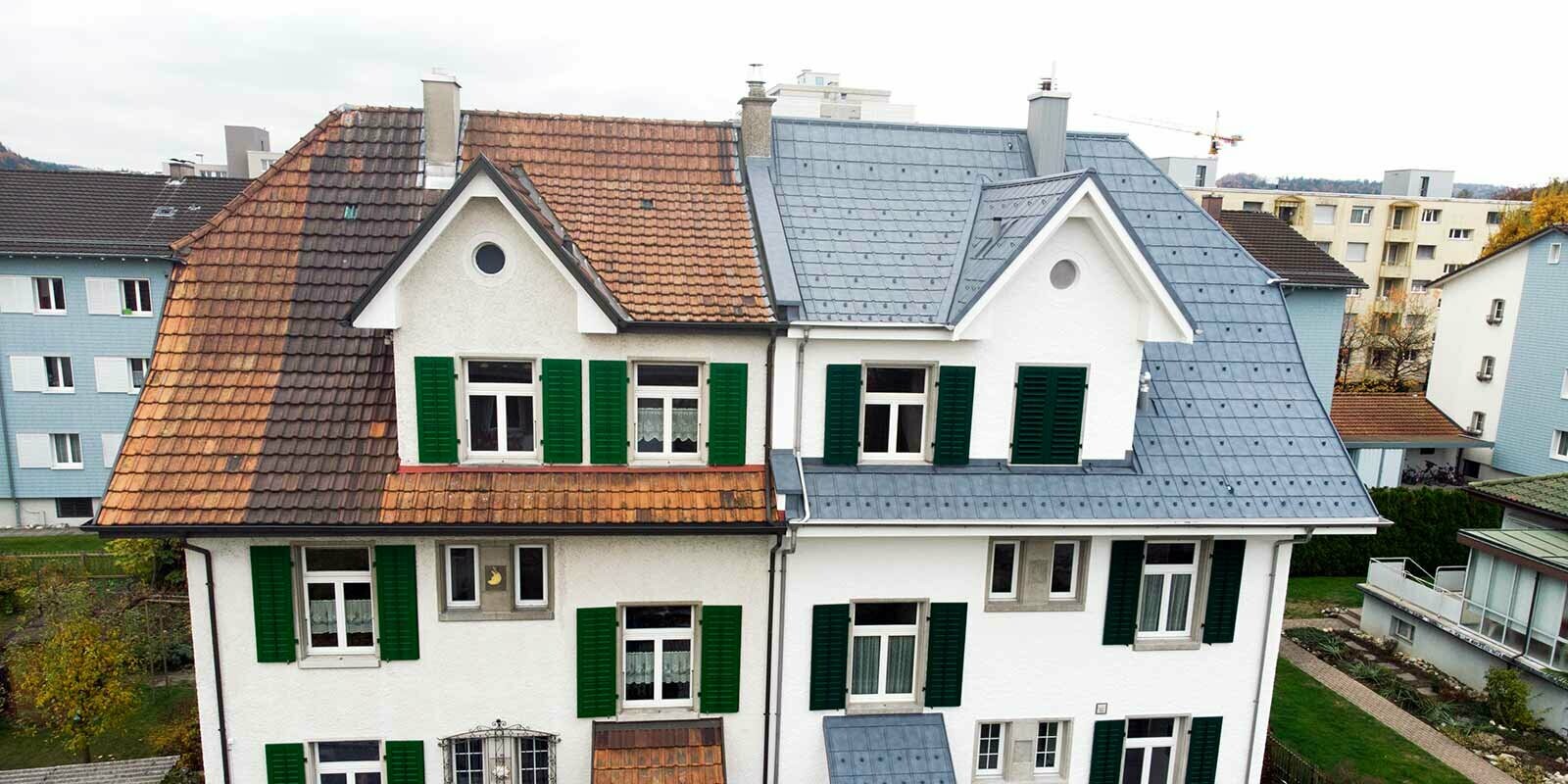 Metà di una casa bifamiliare in Svizzera; la parte sinistra dell’edificio non è ancora stata ristrutturata e presenta ancora una copertura in vecchio laterizio. La copertura della parte destra dell’edificio è stata realizzata con pannelli PREFA grigio pietra.